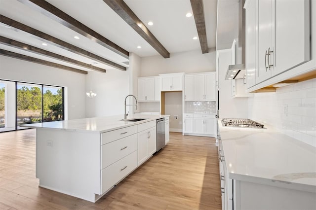 kitchen featuring light stone countertops, a large island, appliances with stainless steel finishes, and white cabinetry