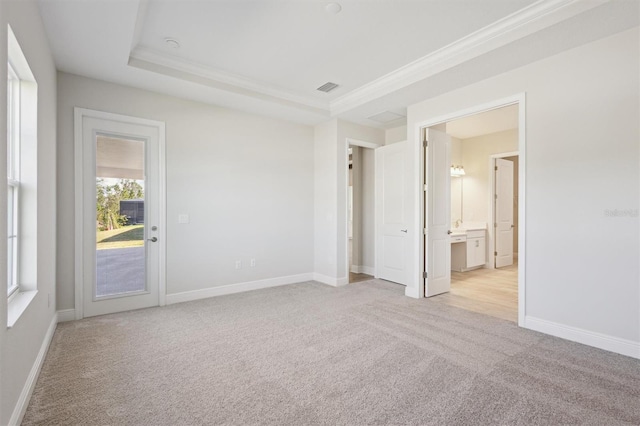 spare room featuring light carpet, ornamental molding, visible vents, and baseboards