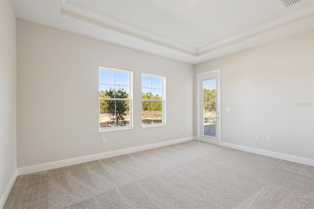 unfurnished room with baseboards, a raised ceiling, crown molding, and light colored carpet