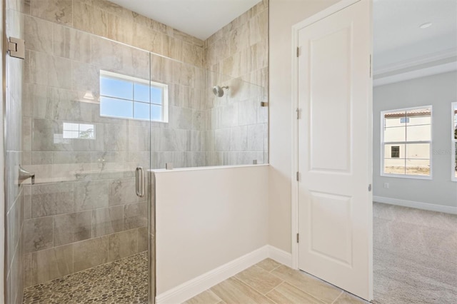 full bath featuring a healthy amount of sunlight, a stall shower, and baseboards