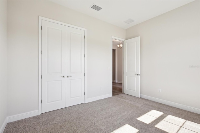 unfurnished bedroom with light carpet, a closet, visible vents, and baseboards