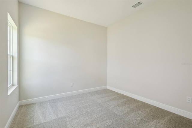 carpeted empty room with visible vents and baseboards