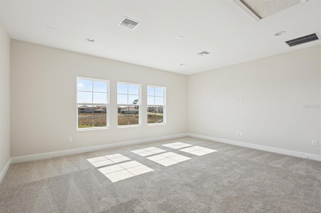 empty room with light carpet, visible vents, and baseboards