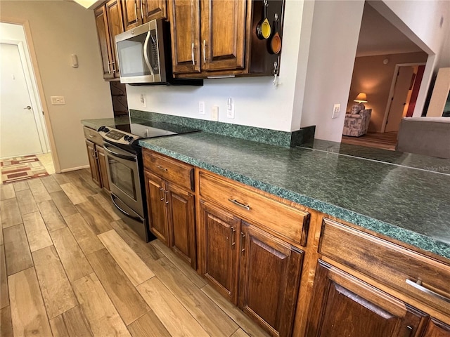 kitchen with stainless steel appliances and light hardwood / wood-style flooring