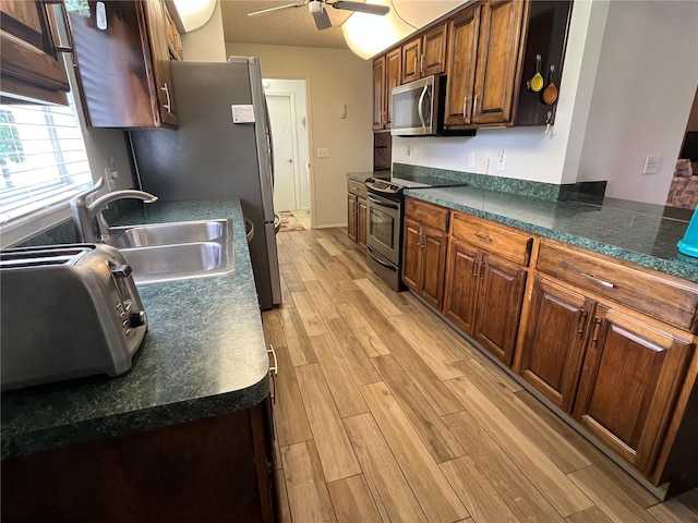 kitchen with sink, light hardwood / wood-style flooring, ceiling fan, and appliances with stainless steel finishes