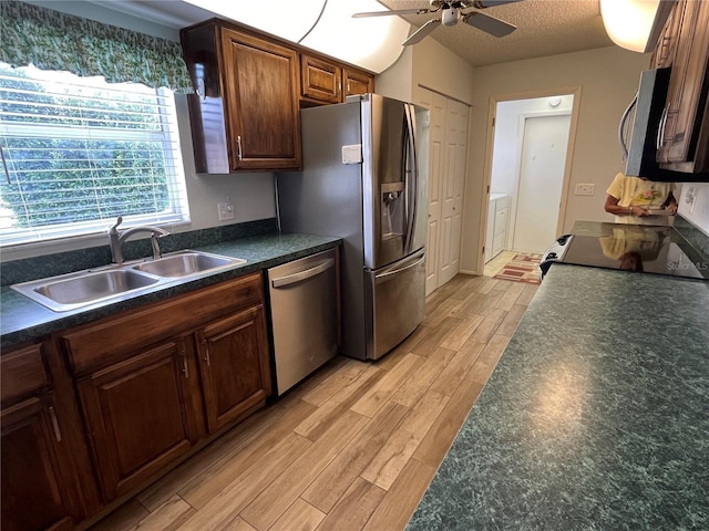 kitchen featuring sink, light hardwood / wood-style flooring, ceiling fan, a textured ceiling, and appliances with stainless steel finishes