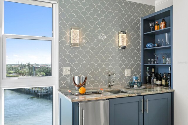 kitchen featuring crown molding, a healthy amount of sunlight, sink, and stainless steel refrigerator