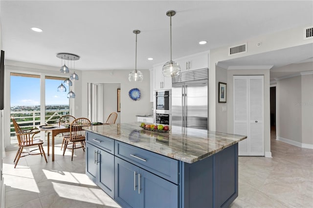 kitchen with a center island, blue cabinets, white cabinetry, appliances with stainless steel finishes, and decorative light fixtures