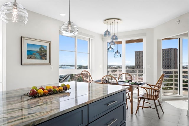 kitchen with pendant lighting, light tile patterned floors, and light stone countertops