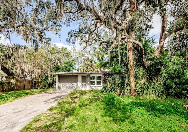 ranch-style home featuring a garage and a front lawn