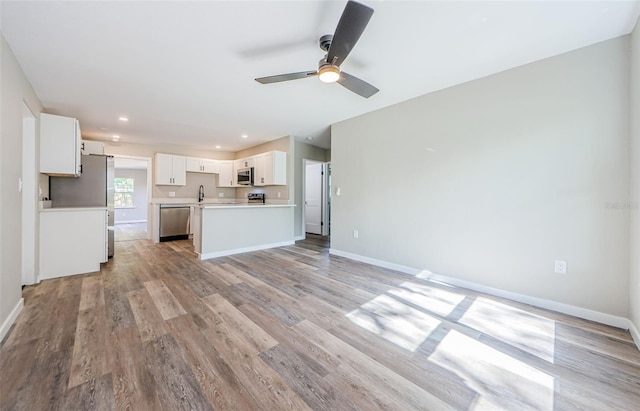 unfurnished living room featuring light wood-type flooring and ceiling fan