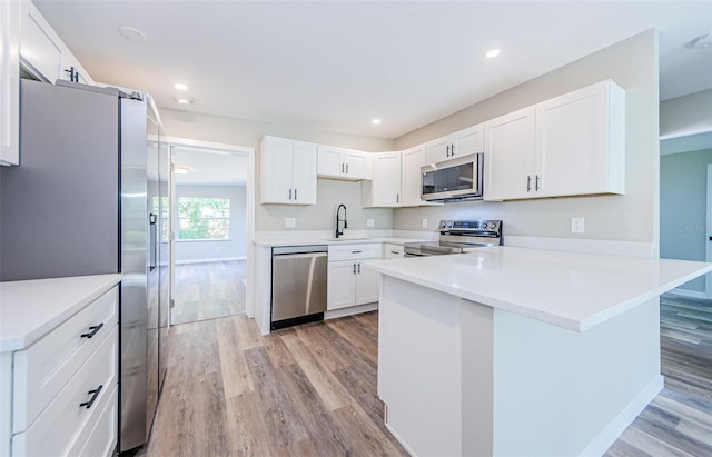 kitchen featuring white cabinets, sink, light hardwood / wood-style floors, and stainless steel appliances