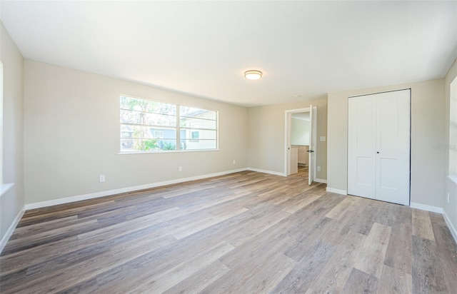 unfurnished bedroom featuring light hardwood / wood-style flooring and a closet