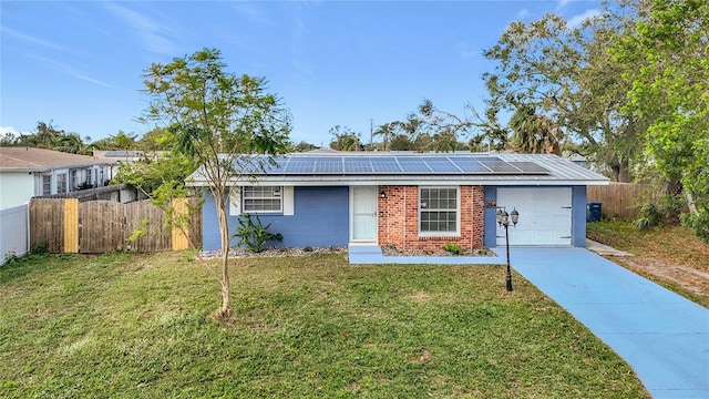 ranch-style house with a garage, solar panels, and a front lawn