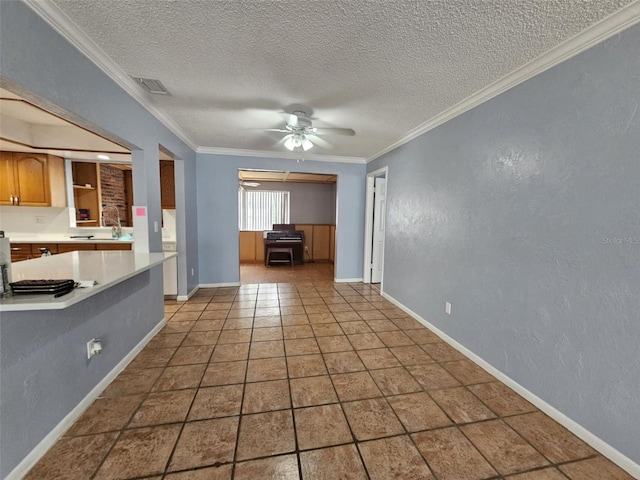 unfurnished living room featuring ceiling fan, a textured ceiling, and crown molding