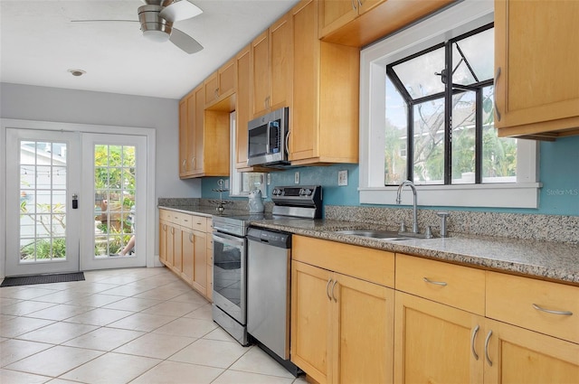 kitchen with stainless steel appliances, a wealth of natural light, ceiling fan, and sink