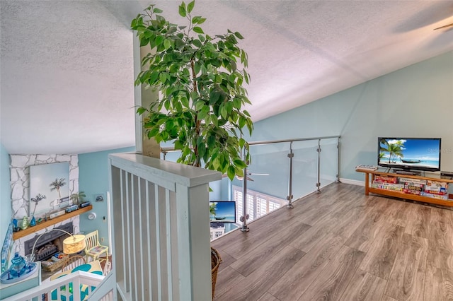 interior space featuring hardwood / wood-style floors, a textured ceiling, and lofted ceiling