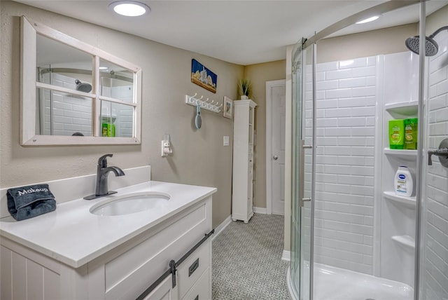 bathroom with walk in shower, vanity, and tile patterned flooring