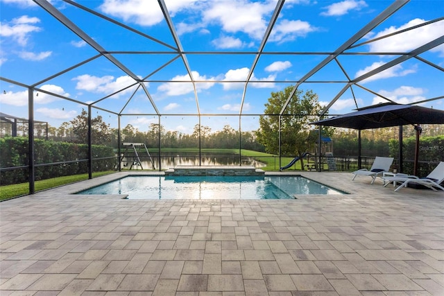 view of swimming pool with glass enclosure and a patio area