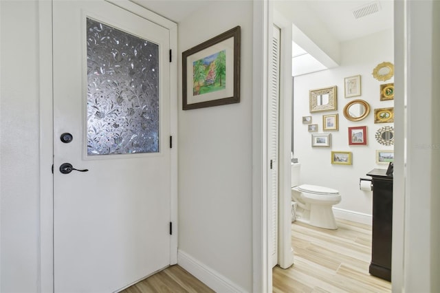 bathroom with toilet, vanity, and hardwood / wood-style flooring