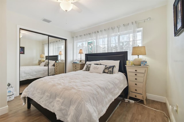 bedroom featuring ceiling fan, a closet, and hardwood / wood-style flooring