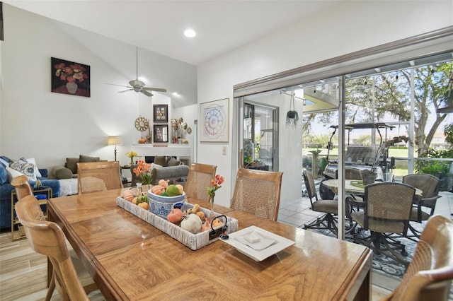 dining area with ceiling fan, high vaulted ceiling, and light hardwood / wood-style floors