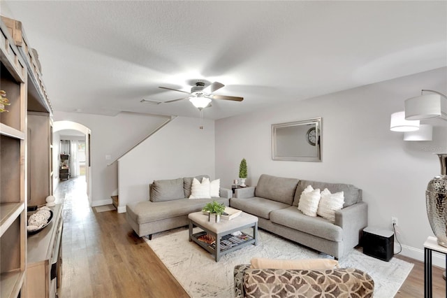 living room featuring hardwood / wood-style floors, ceiling fan, and a textured ceiling