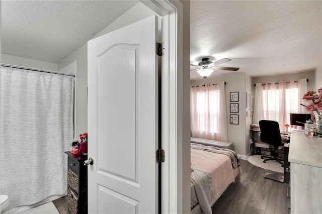 bedroom with hardwood / wood-style flooring, ceiling fan, and a textured ceiling