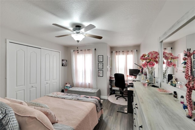 bedroom featuring a textured ceiling, a closet, dark hardwood / wood-style floors, and ceiling fan