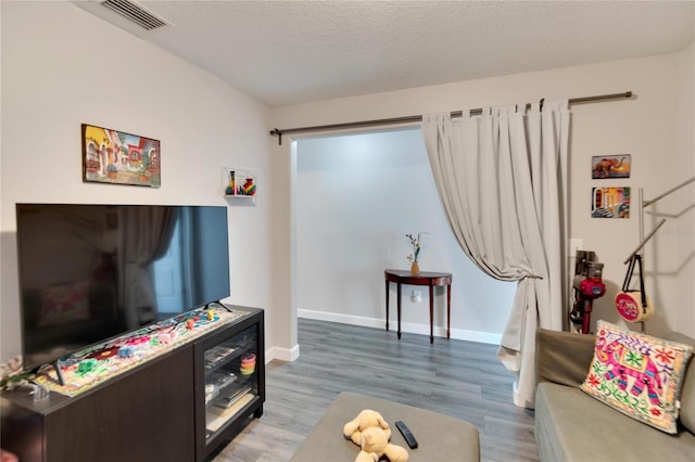 living room with wood-type flooring and a textured ceiling