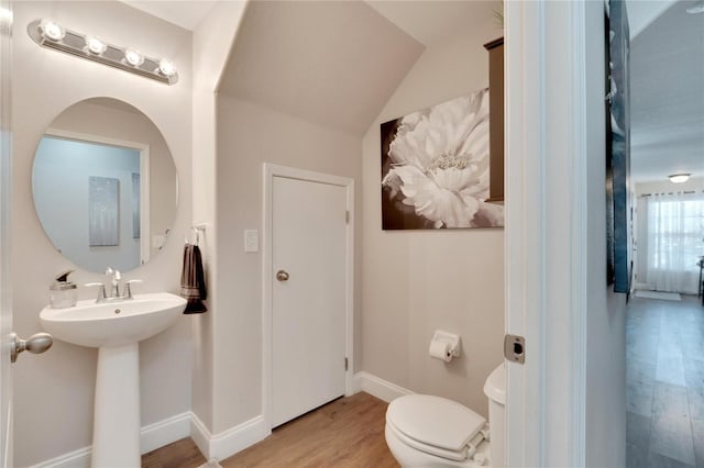 bathroom featuring hardwood / wood-style floors, vaulted ceiling, and toilet