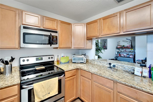 kitchen with light stone counters, light brown cabinetry, a textured ceiling, and appliances with stainless steel finishes