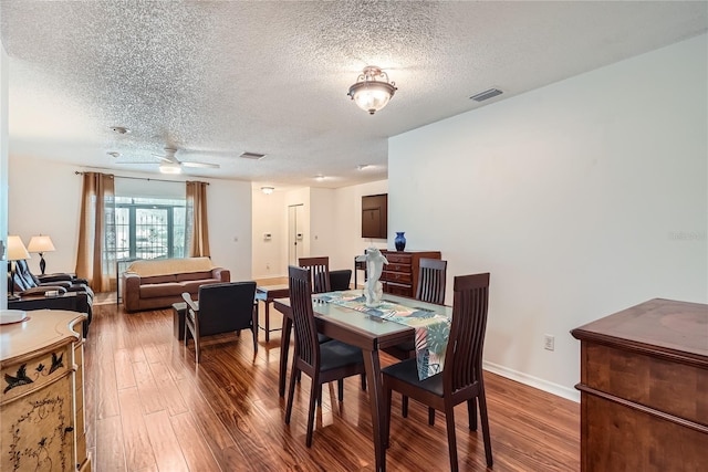 dining area with hardwood / wood-style flooring, ceiling fan, and a textured ceiling