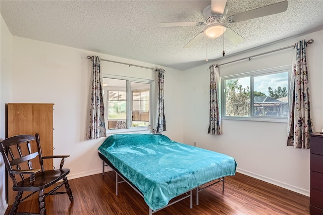 bedroom featuring hardwood / wood-style flooring, ceiling fan, and a textured ceiling