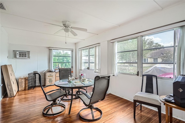 dining area featuring an AC wall unit, hardwood / wood-style flooring, and ceiling fan