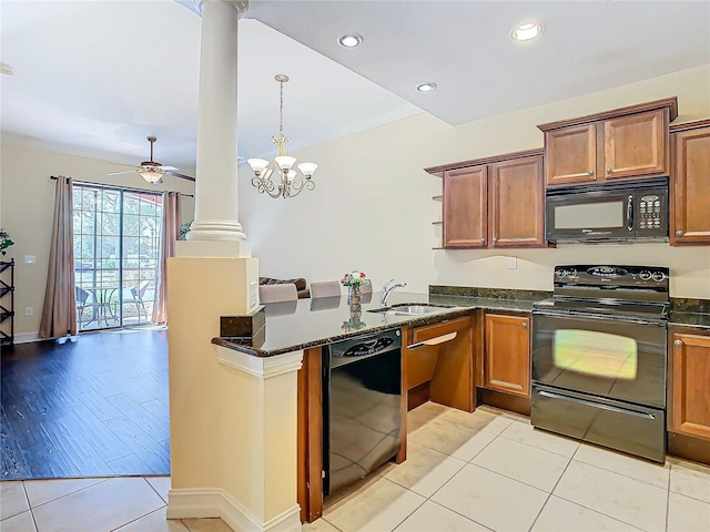 kitchen featuring black appliances, sink, decorative columns, kitchen peninsula, and light hardwood / wood-style flooring