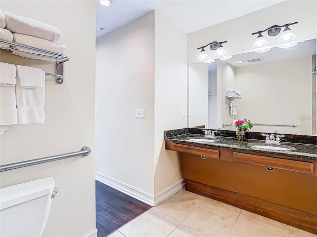 bathroom with toilet, vanity, and tile patterned floors