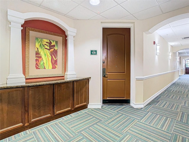 corridor with a paneled ceiling, ornate columns, and carpet floors