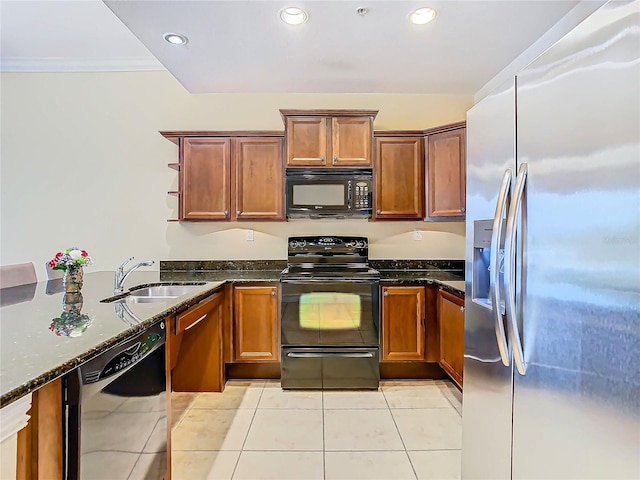 kitchen featuring black appliances, dark stone counters, sink, and light tile patterned floors