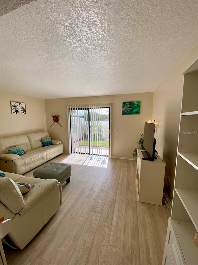 living room with light hardwood / wood-style flooring and a textured ceiling