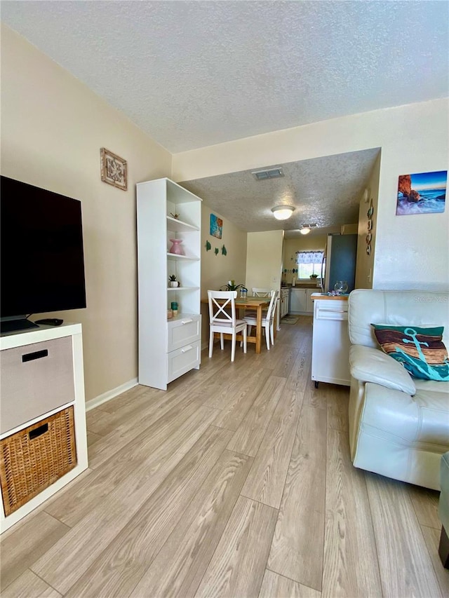 living room featuring a textured ceiling and light hardwood / wood-style flooring