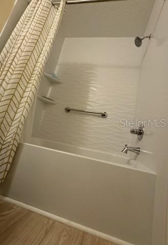 bathroom featuring wood-type flooring and shower / washtub combination