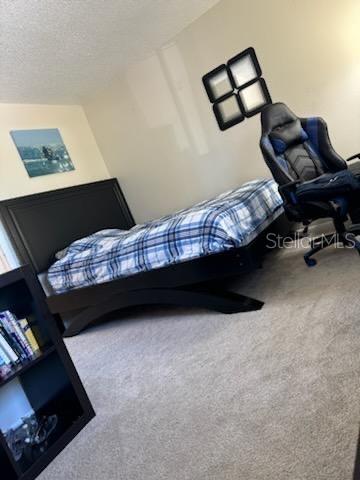 carpeted bedroom featuring a textured ceiling