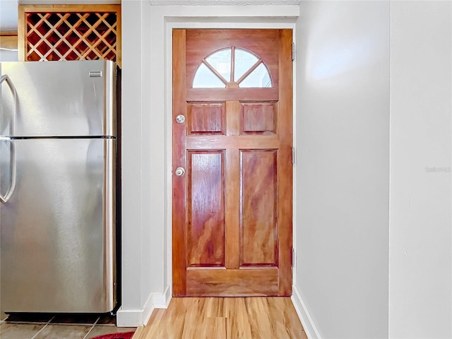 interior space with light wood-type flooring and stainless steel refrigerator