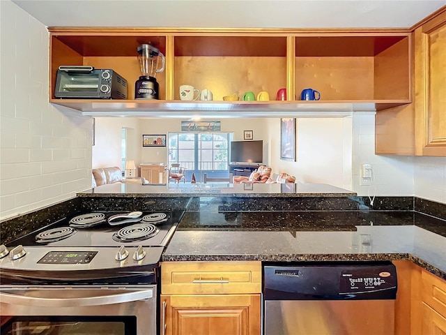 kitchen with stainless steel appliances, dark stone counters, and tasteful backsplash