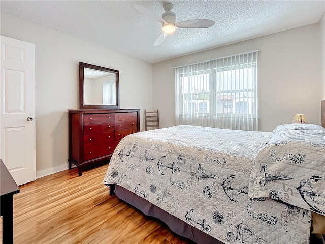 bedroom featuring wood-type flooring, ceiling fan, and a textured ceiling