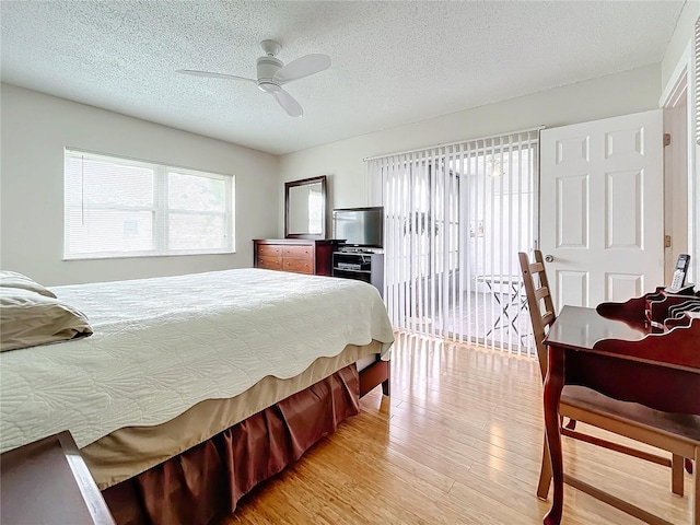 bedroom with light wood-type flooring, a textured ceiling, ceiling fan, and access to exterior