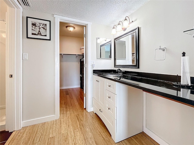 bathroom featuring vanity, a textured ceiling, and hardwood / wood-style flooring