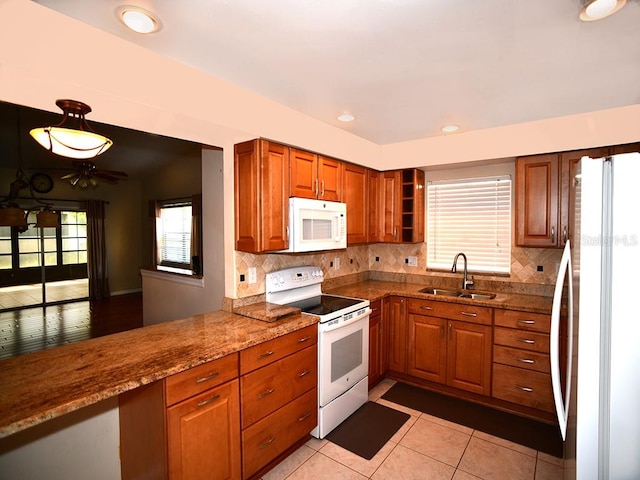 kitchen featuring light stone counters, sink, tasteful backsplash, ceiling fan, and white appliances