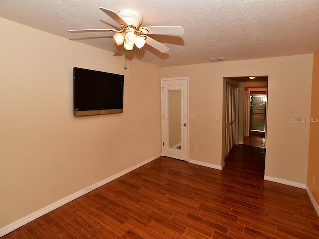 spare room featuring ceiling fan, a textured ceiling, and dark hardwood / wood-style floors